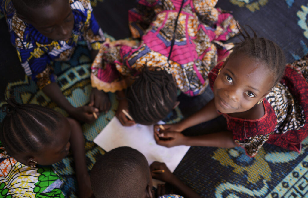 Group Of Ugandan Children Working With Paper And Drawing.