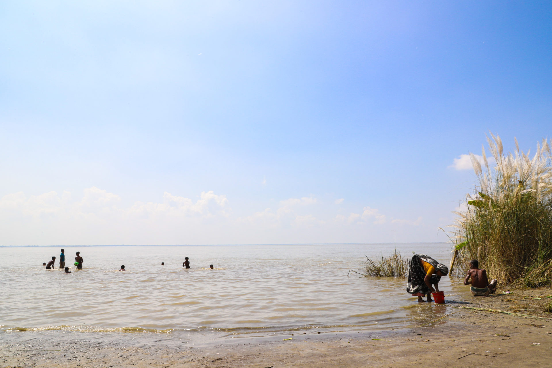 Village Couple And Children Bathing At The Bank Of Padma River In Bangladesh. Adobe Photos
