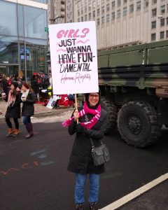 Kelley Dennings holding a sign that says "Girls just wanna have fundamental human rights"