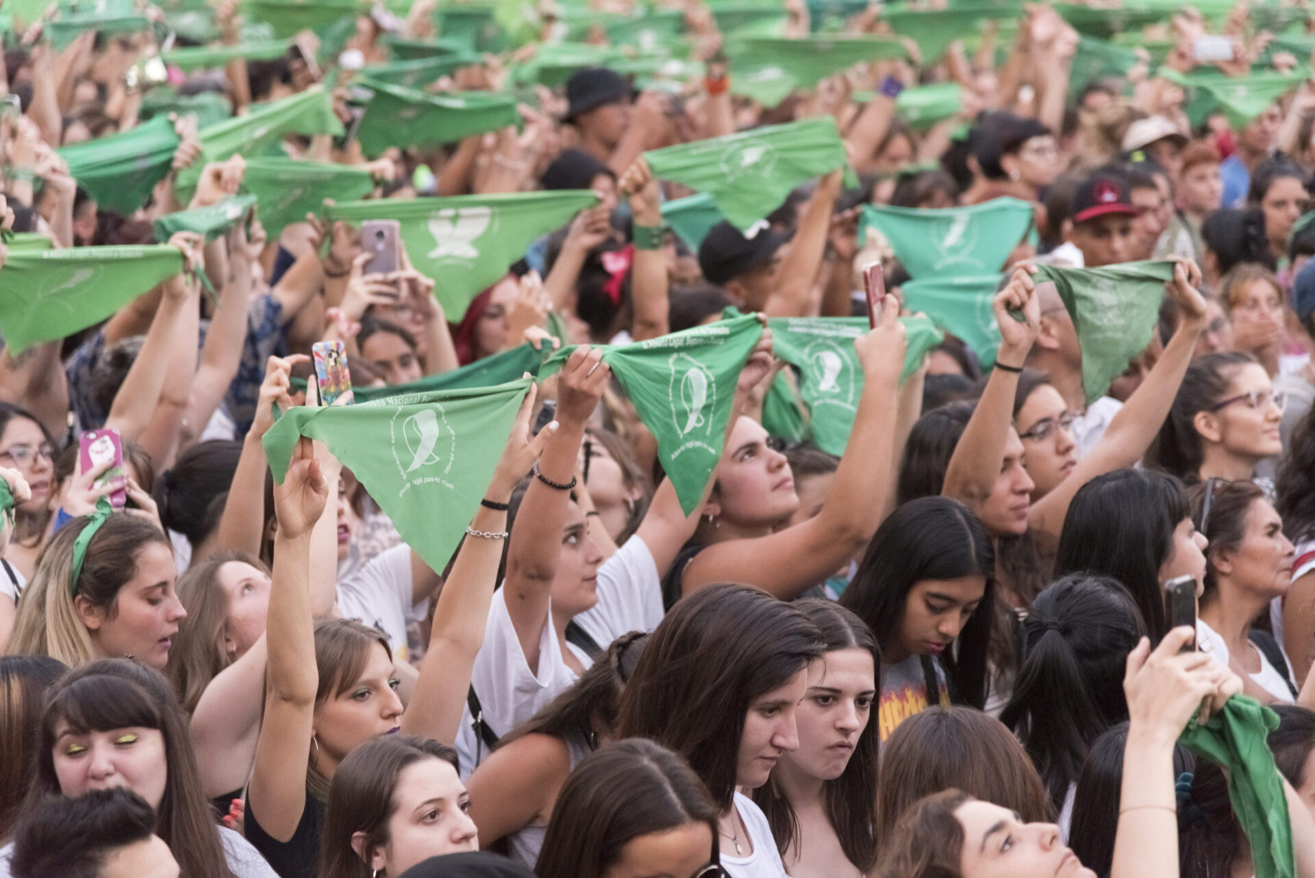 Women at a rally on February 19, 2020, in Buenos Aires, Argentina, raise green handkerchiefs, a symbol of support for legal, safe, and free abortion in Latin America. © Carolina Jaramillo | Dreamstime.com