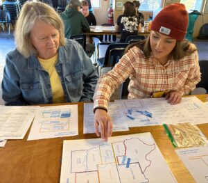 Two teachers sit next to each other and do an activity on a map of the US High Plains