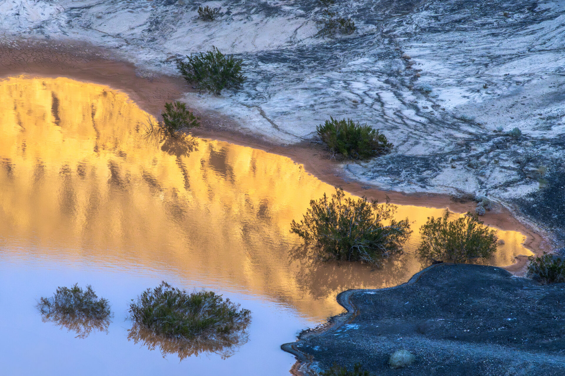 The pool of water reflects the sun shining off the surrounding mountains at the Ubehebe Crater in Death Valley National Park. Submitted by: Steve Harris