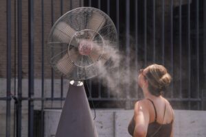 A tourist is sprayed with cooling mist at the Colosseum in Rome