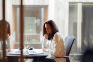 A woman working at a laptop in an office